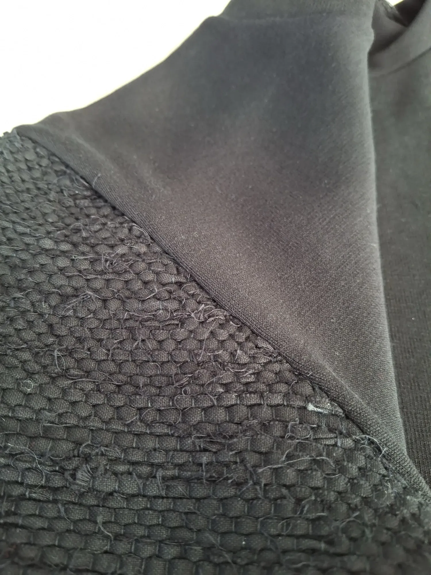 Black Solitaire t-shirt — woven texture detail where sleeve meets body