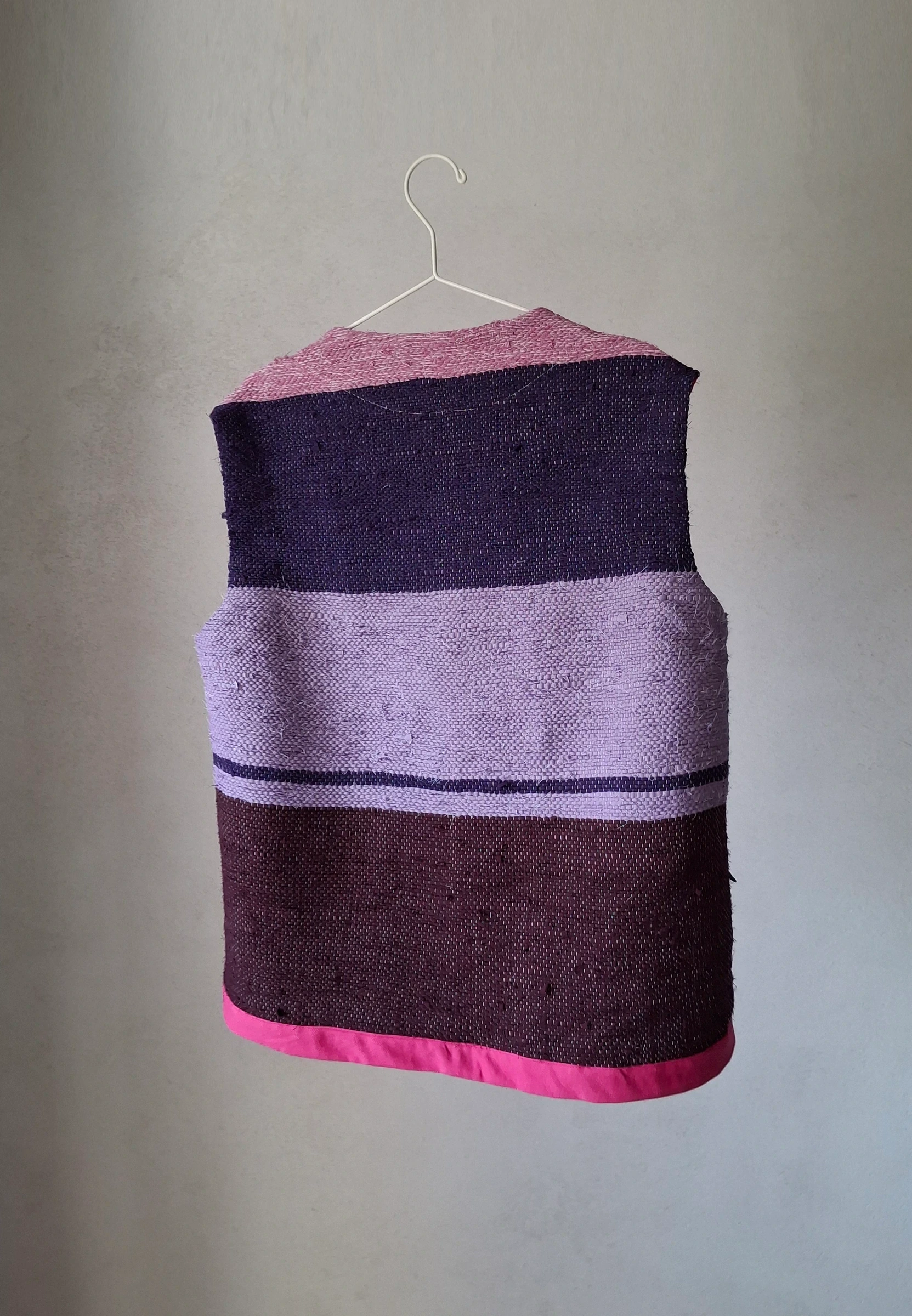 Back of the vest — handwoven panel in violet, aubergine and dark magenta stripes