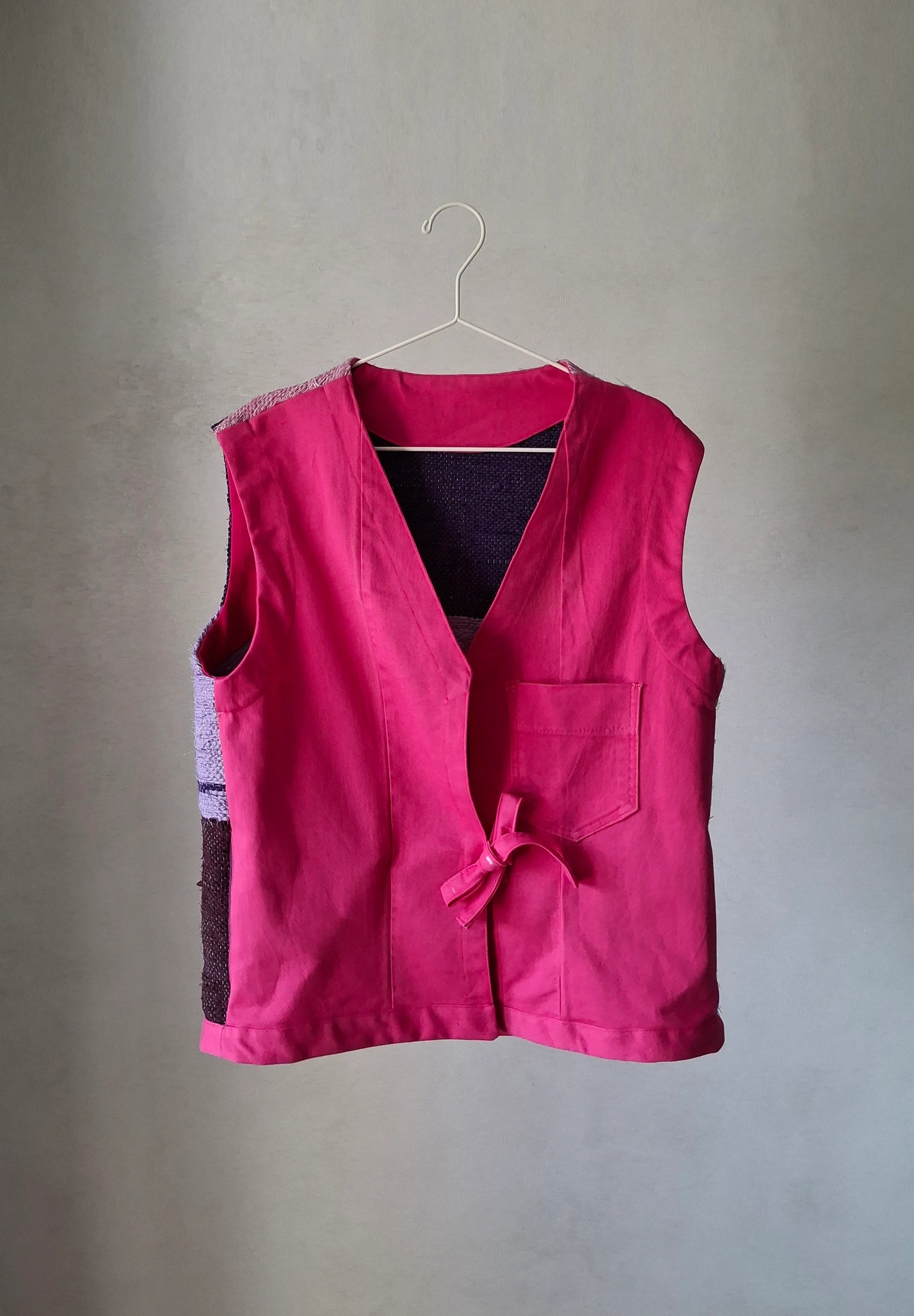 Handwoven upcycled vest with a cyclamen denim front, fabric-ribbon tie and a patch pocket