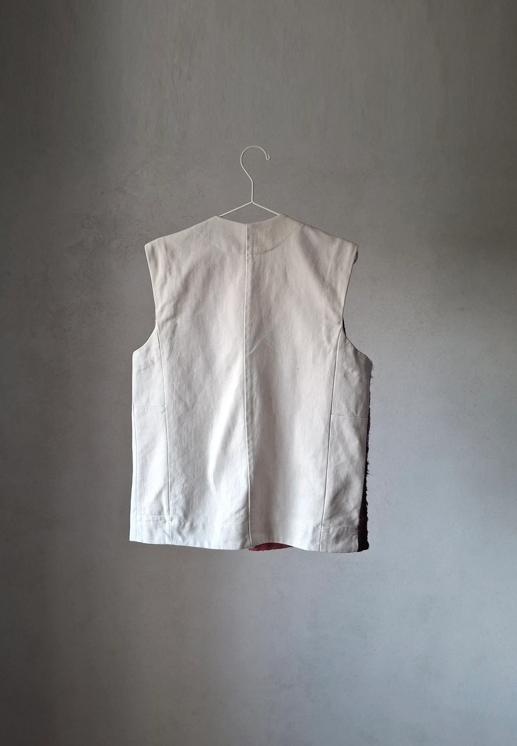 Back of the off-white vest in pale recycled denim